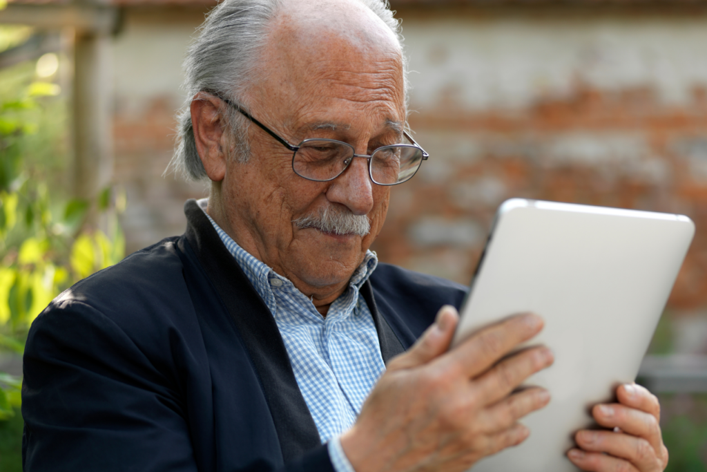 older man reading tablet